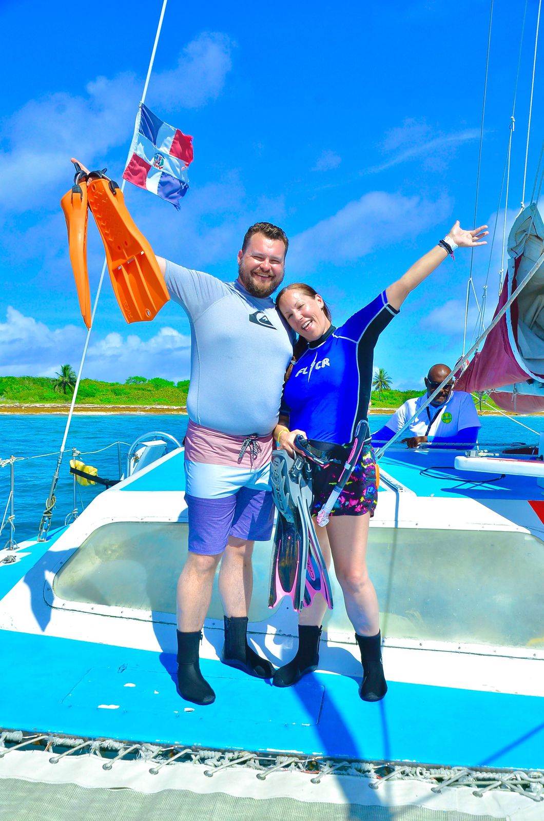 Pareja feliz en catamaran con aletas listas para bucear