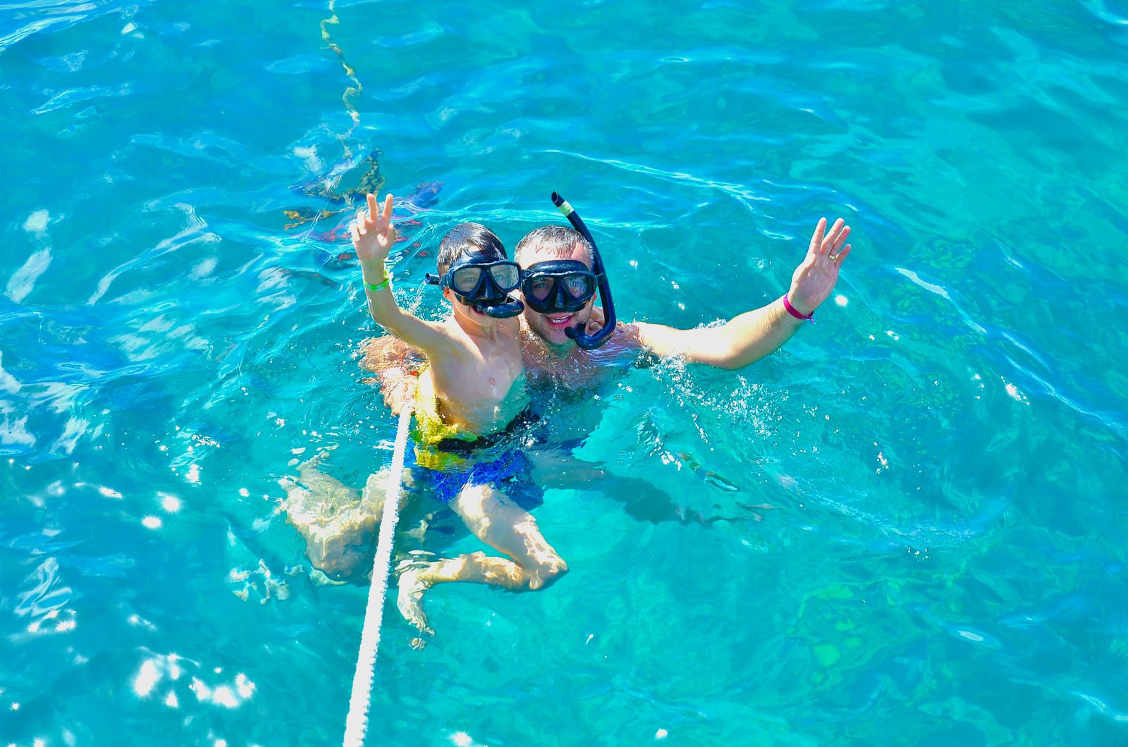 Familia disfrutando del snorkel en aguas cristalinas turquesa